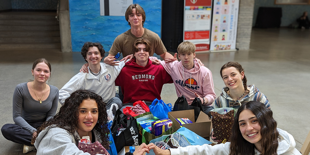 Photo of FJR students with the bags and boxes of items donated.