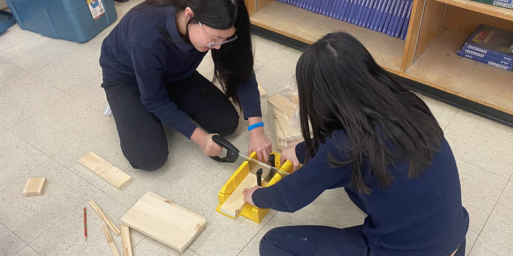 Photo of two students working together on a carpentry project.