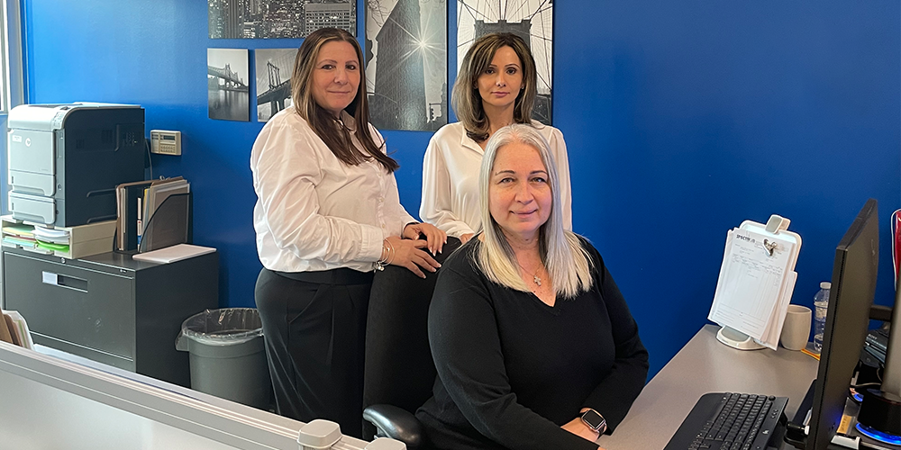 Banner - Photo of three administrative professionals at a computer terminal in an office