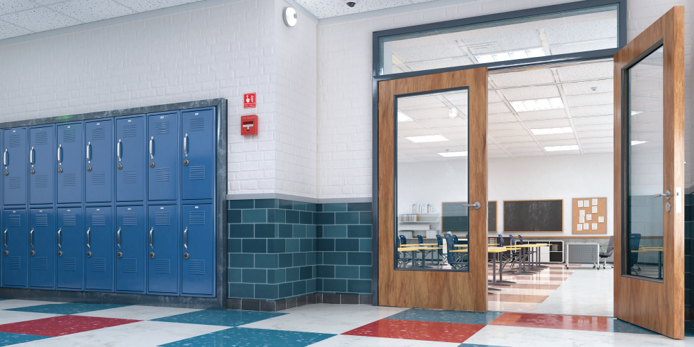 An image of a school hallway with blue lockers looking into an empty classroom.
