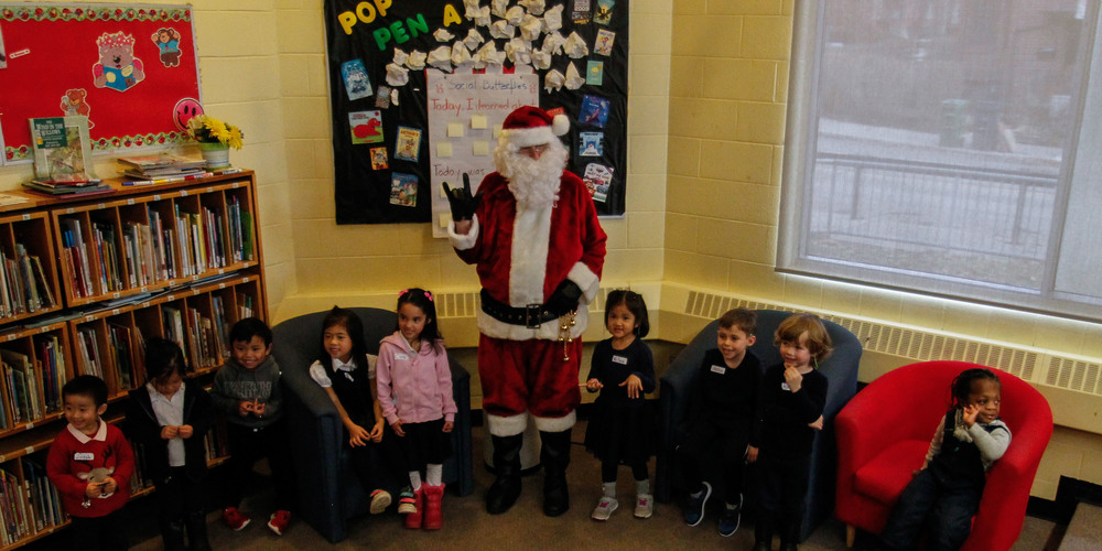 Banner - Photo of Santa posing with students