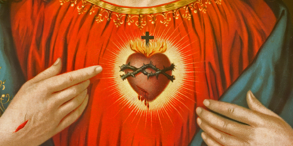 An artwork illustrating the Sacred Heart. Atop the heart is a cross with flames and a halo of divine light. The heart is surrounded by a crown of thorns, and is pierced and bleeding.