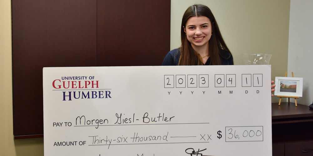 Banner - Photo of Morgen holding the scholarship cheque.