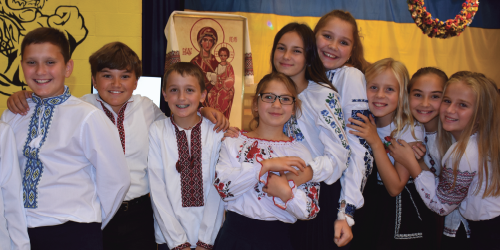 A group of students wearing Vyshyvankas smiling at the camera.