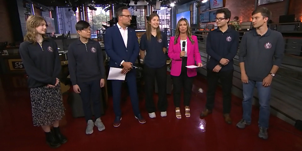 Photo of Father John Redmond students standing with CTV news anchors to be interviewed.