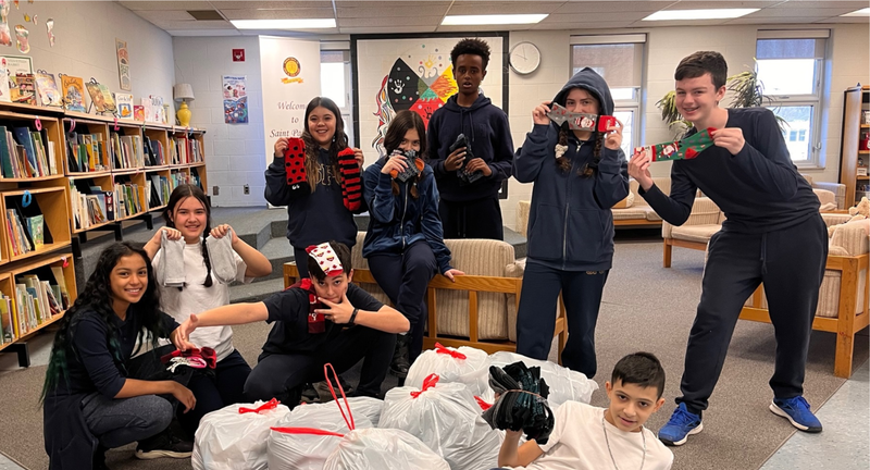 Students posing with bags of socks collected for sock drive
