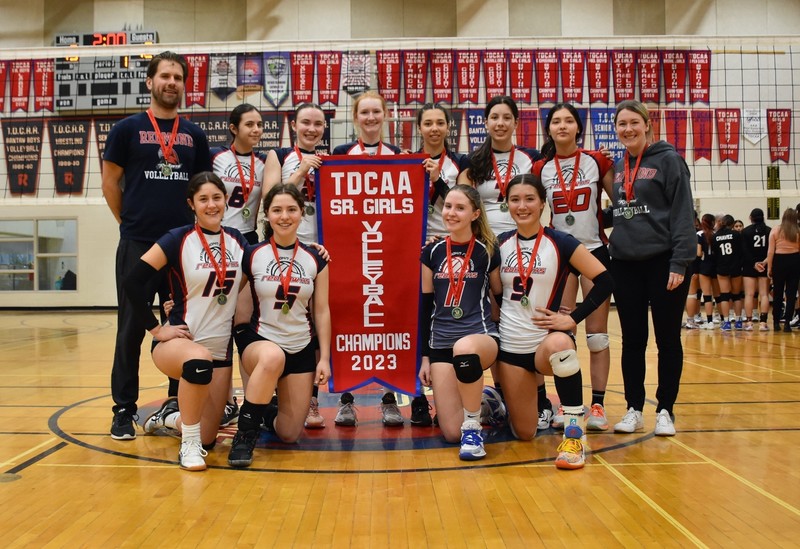 Photo of Father John Redmond's Senior Girls Volleyball Team posing with their TDCAA championship banner, along with the team coaches