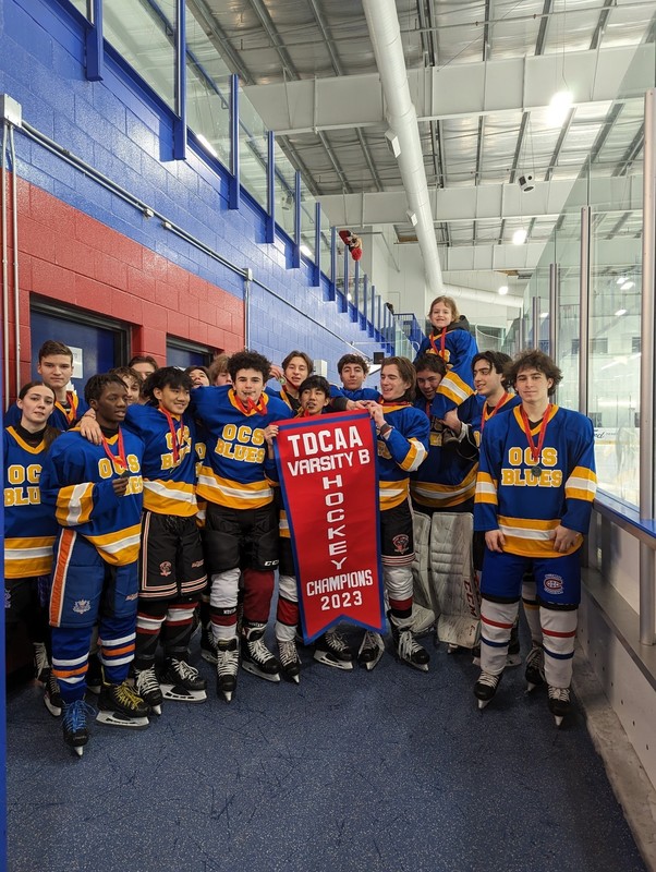 Senator O'Connor Varsity B hockey team posing in uniform with their TDCAA championship banner
