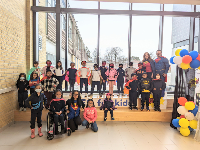 Group photo of St. Paschal Baylon students and staff, most of them in various superhero costumes