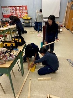 Photo of students working together in the shop on a carpentry project.