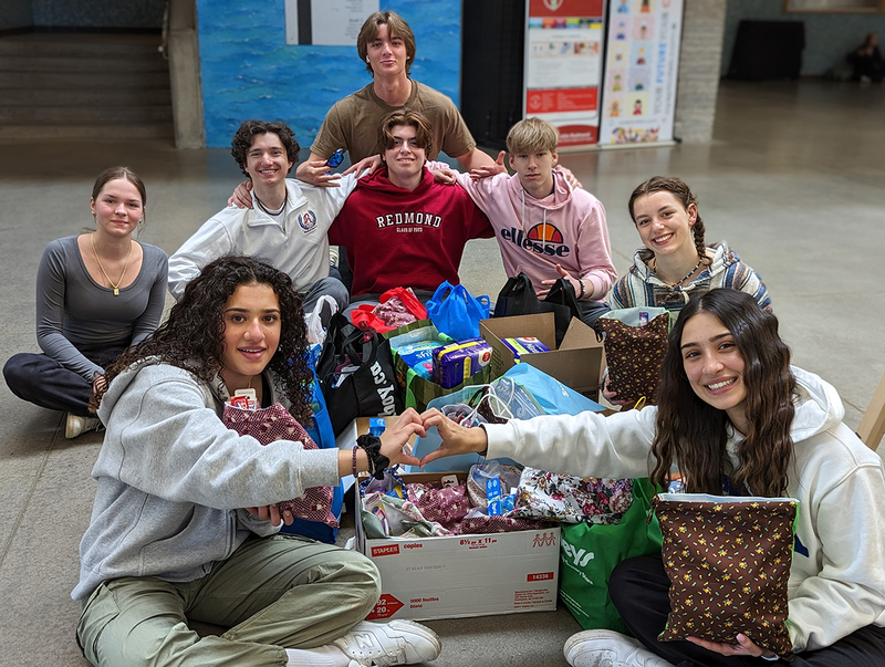 Photo of FJR students with the bags and boxes of items donated.