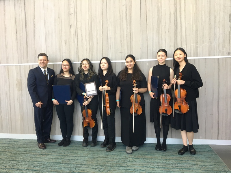 Group photo of St. Joseph's College School String Ensemble - From left to right - Dr. Daniel Hasznos (Music Teacher), Jingfei N., Dora L., Yoonsuh K., Veronika K., Lily Y. M., and Evelyn C.