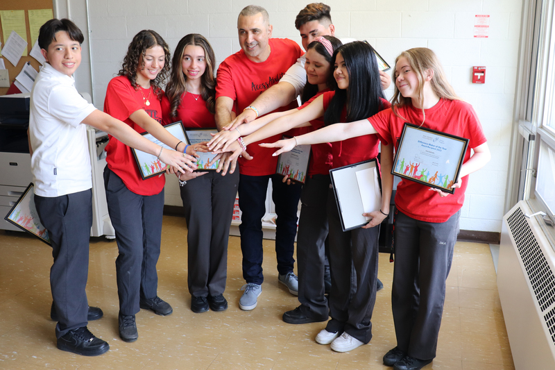 Seven students celebrating their award with their teacher. Photo credit: Joseph Vukman