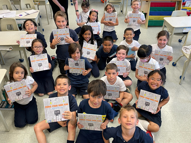 Group photo of Grade 2 St. Bonaventure Students holding up their co-written book "Make Your Own Fun!"