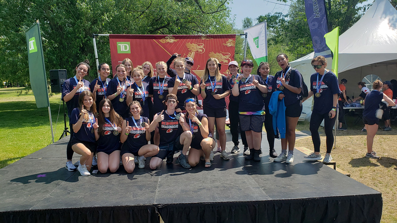 FJR dragonboat team posing on the podium with their medals