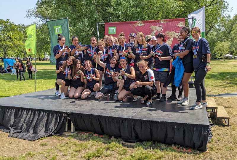 FJR dragonboat team posing on the podium with their medals