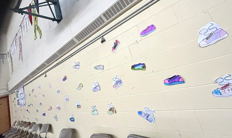 Mother Cabrini Catholic School's gym walls decorated with drawings of running shoes by the students