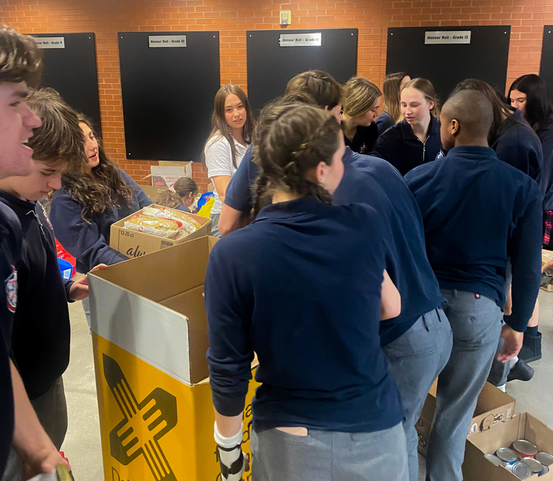 Father John Redmond students putting the non-perishable food item donations into boxes to be donated to Daily Bread Food Bank